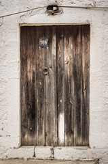 Old timber door in the scuffed wall