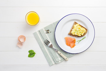 Top view of healthy breakfast with scrambled eggs on toast