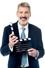 Smiling man showing a clapperboard to the camera