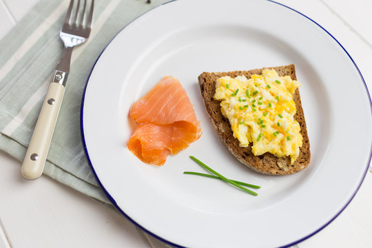 Healthy breakfast with scrambled eggs on toast and salmon