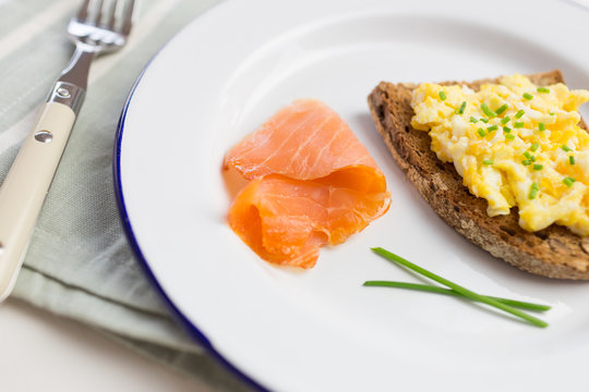 Smoked salmon close-up with scrambled eggs with chives