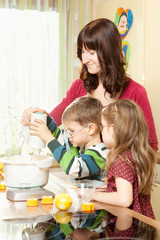Junge Eltern backen in der Küche mit ihren Kindern
