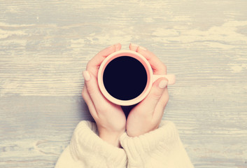 Female hands holding cup of coffee.
