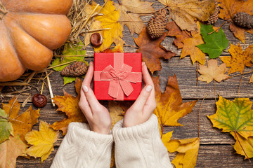 Female holding gfit box on a table.