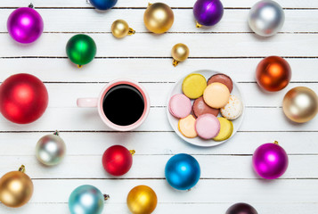 Cup of coffee and macaron with christmas toys on whte background