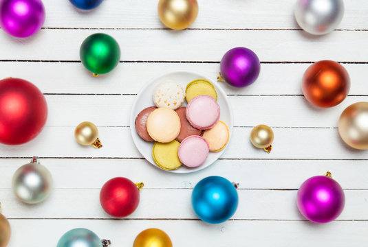 Macaron on plate and christmas balls around.