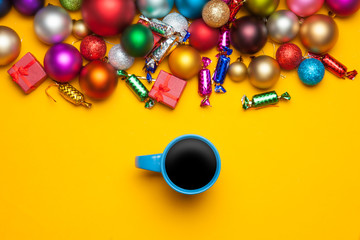 Cup of coffee and christmas gifts on yellow background.