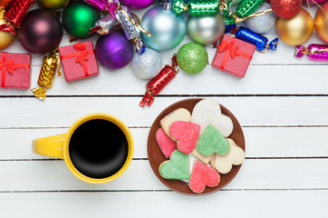 Cup of coffee and cookie with christmas toys on whte background.