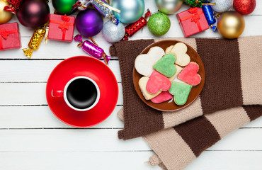 Cup of coffee and cookies near christmas toys.