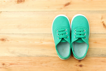 Green shoes on wooden floor.