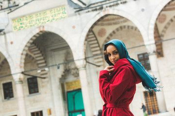 Young Arabian Woman wearing Veil in front of a Mosque