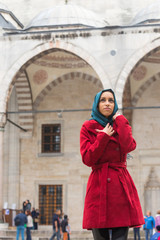 Young Arabian Woman wearing Veil in front of a Mosque