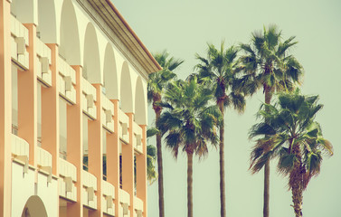Portrait of tropical apartment building with palms.