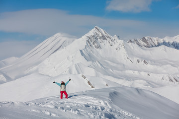 Naklejka na ściany i meble Hiker posing at top of snowy mountain during sunny day