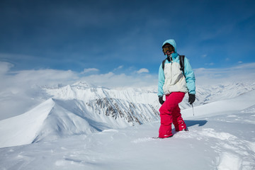 Fototapeta na wymiar Hiker posing at top of snowy mountain during sunny day