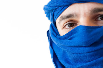 Fototapeta premium Close up of man wearing a blue keffiyeh against white background