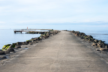 breakwater in the sea with lighthouse on it