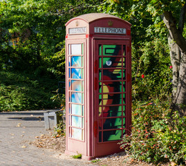 Obraz premium painted old red phone booth, phone box, painted in different col