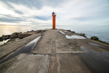 breakwater in the sea with lighthouse on it