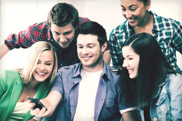 students looking into smartphone at school