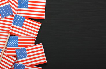 Obraz premium Miniature USA flags on a blackboard with copy space