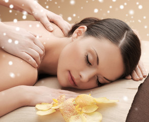 Obraz na płótnie Canvas beautiful young woman in spa salon getting massage
