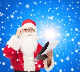 man in costume of santa claus with notepad