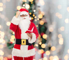man in costume of santa claus with notepad