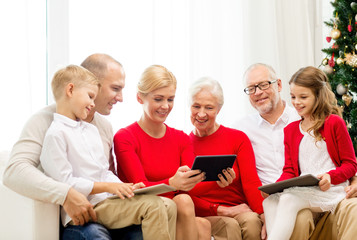 smiling family with tablet pc computers at home