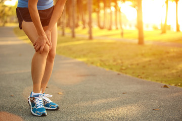woman runner hold her sports injured knee 