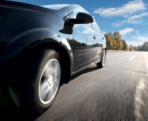 Front side view of black car in turn.