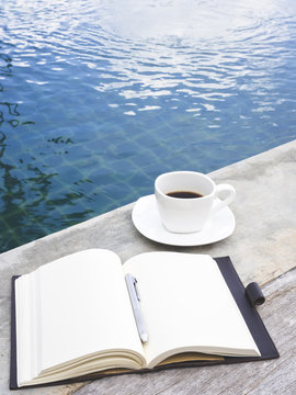 Coffee cup and sktech Book by Swimming Pool leisure relax Lifestyle