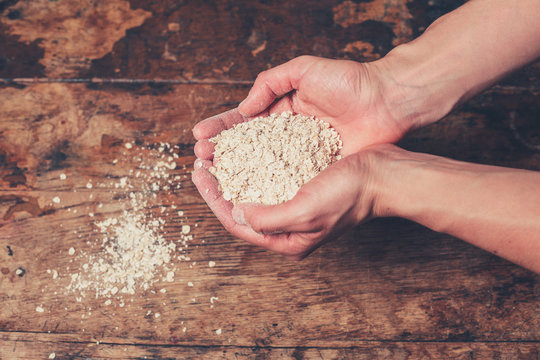 Hands mixing oats on table