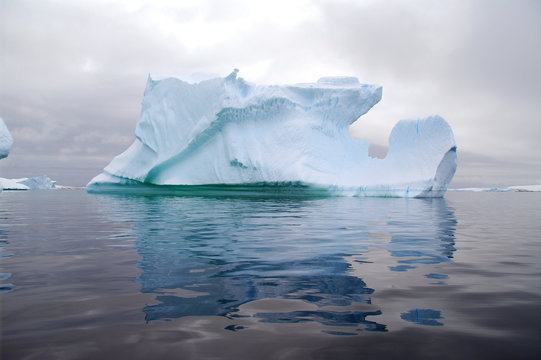 huge iceberg reflected in the ocean