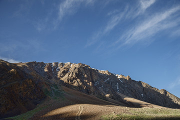 View of shadowed side jagged mountains with snow