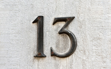 Closeup image of an old rusted metal number 13 - 72594829