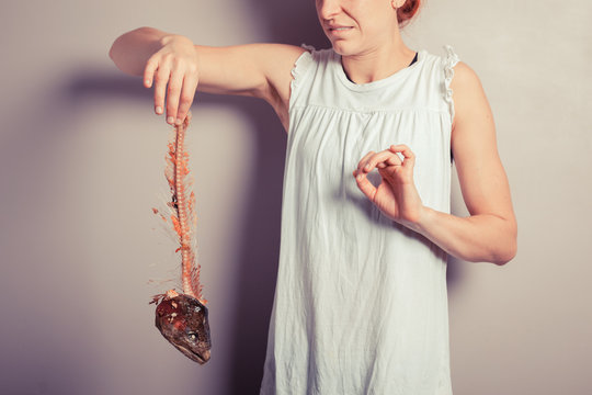 Disgusted woman with fish skeleton