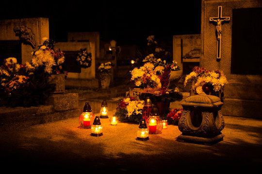 cemetery decorated with candles for All Saints Day at night