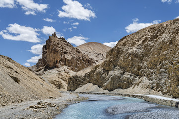 river flow and road nearby in jagged mountains