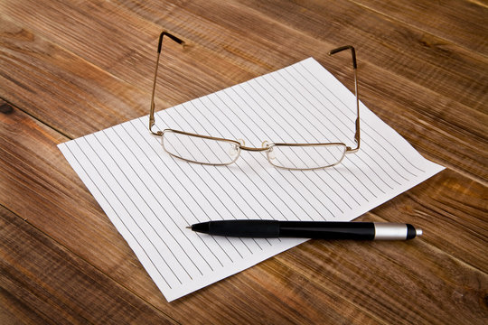 paper, pen and glasses - Powered by Adobe