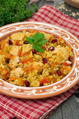 pilaf with vegetables, chicken and pomegranate on a plate