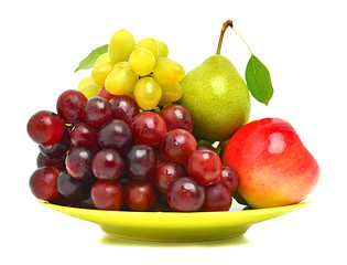 Ripe grape, the apple and pear on the plate