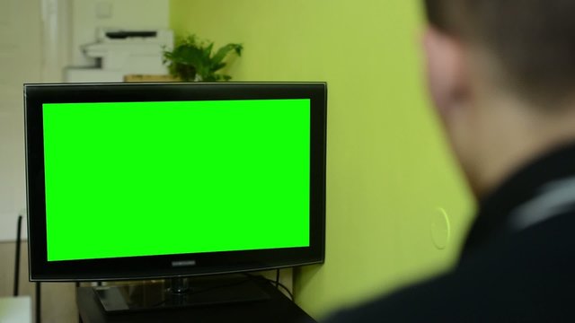 Man watches TV(television) - green screen