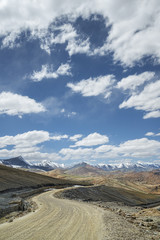 View of curved road among snow capped mountains