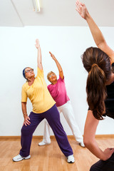 Personal trainer doing aerobic with senior ladies.