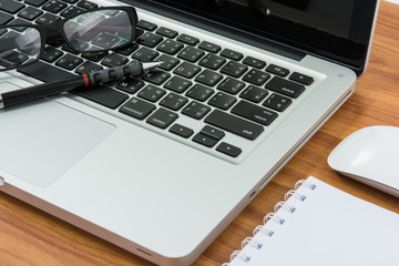 Blank business laptop, mouse, pen, note and glasses