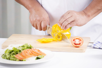 Obraz na płótnie Canvas Chef's hands cutting yellow bell pepper