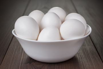 eggs in white bowl on wooden table