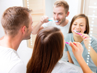 Young couple in the bathroom brushing teeth together