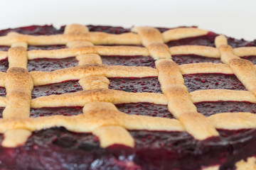 Gitterkuchen mit Waldbeeren vor weissem Hintergund